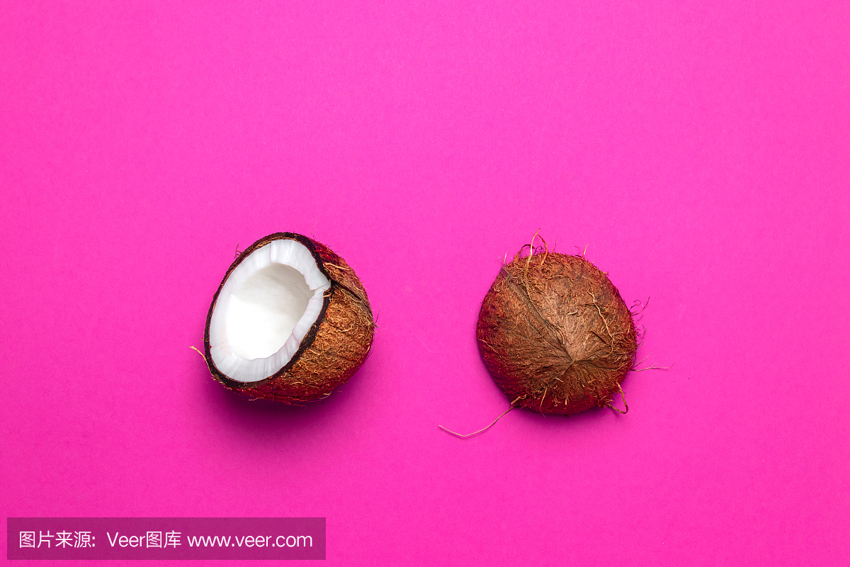 粉色背景上切成一半的椰子